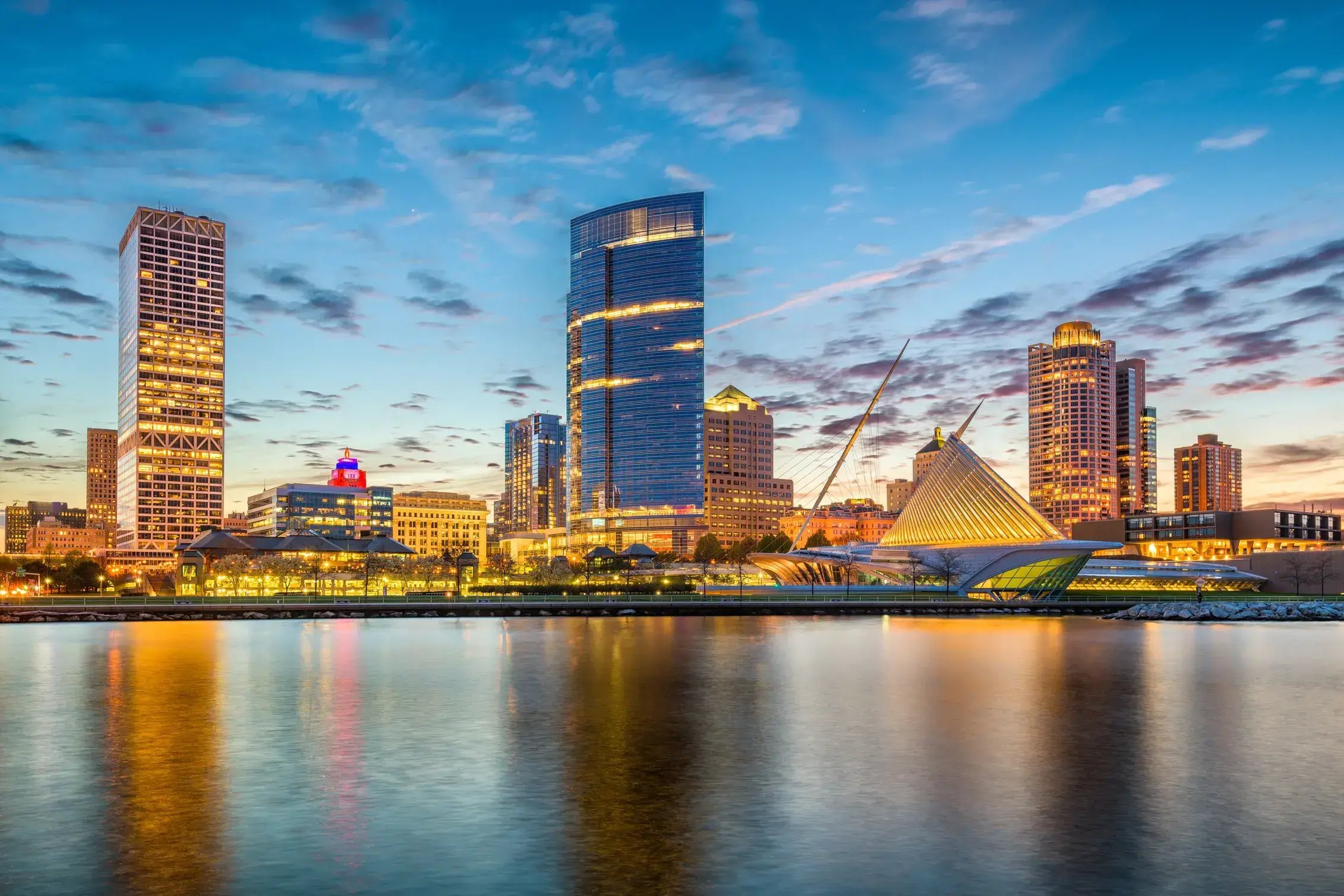 Milwaukee skyline at sunset featuring the Milwaukee Art Museum along the Lake Michigan waterfront.