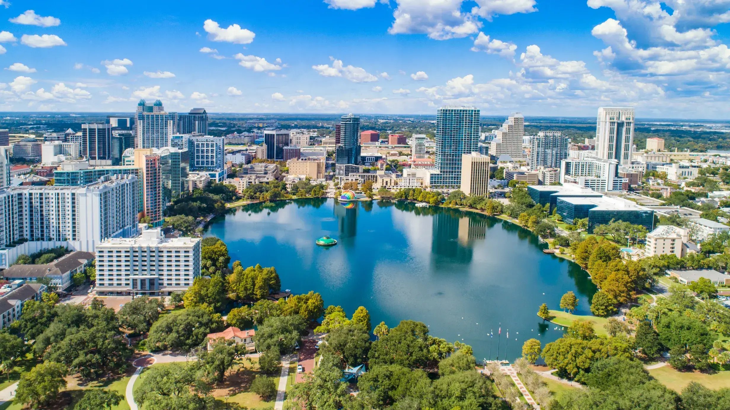 Aerial view of downtown Orlando surrounding Lake Eola on a bright, sunny day.