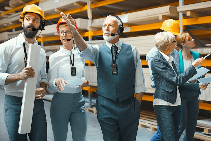 People Wearing Hardhats and Headsets On Factory Floor