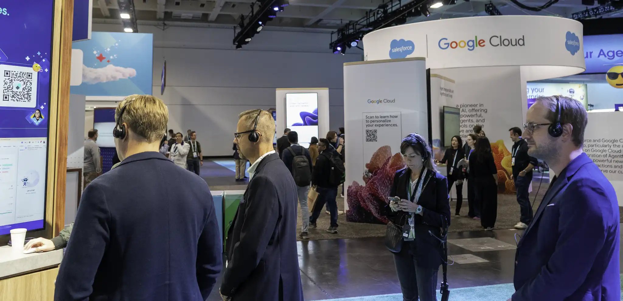 Visitors wear listening headsets while viewing a product demo on a busy expo floor.