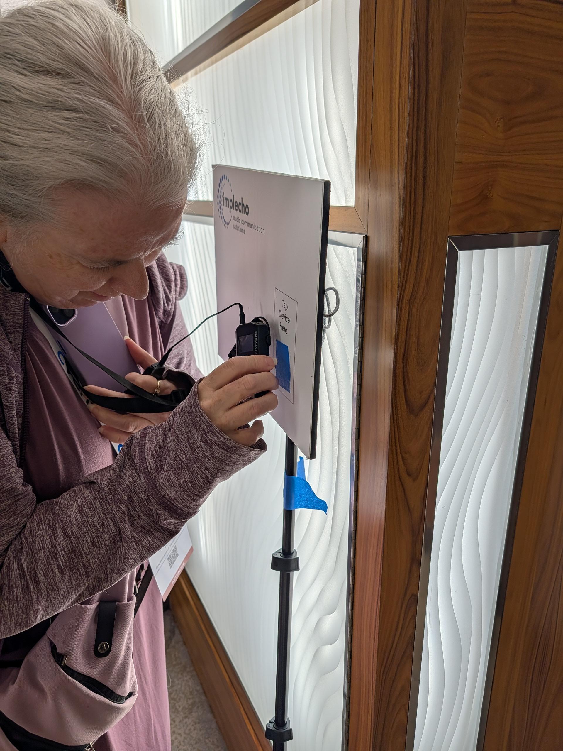 Woman using Implech tapboards with ListenTalk device